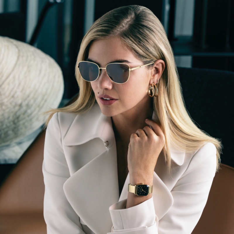 Supermodel Kate Upton showcases Anne Klein's spring 2024 collection with a crisp white blazer and square sunglasses.