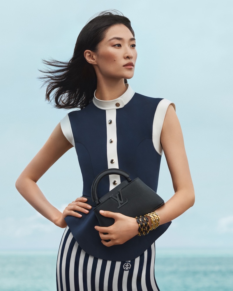 Chu Wong poses at sea, appearing in the Louis Vuitton handbag spring 2024 ad.
