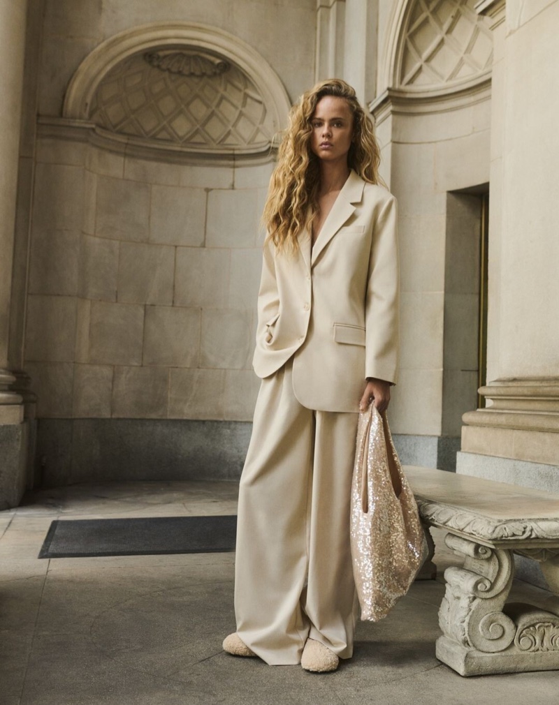 Wearing a relaxed cream-colored suit, Olivia Vinten appears in the Reserved spring 2024 campaign.