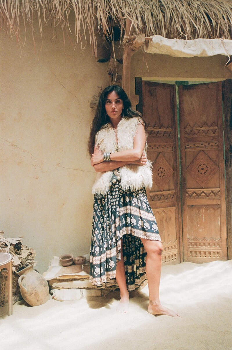Laura Bensadoun embraces rustic elegance with a faux-fur vest and printed skirt in Spell's Bohemian Royale Renew collection.