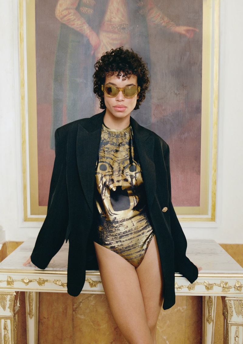 H&M Studio's resort 2024 collection features a striking gold-print swimsuit, styled with an oversized blazer and sunglasses.