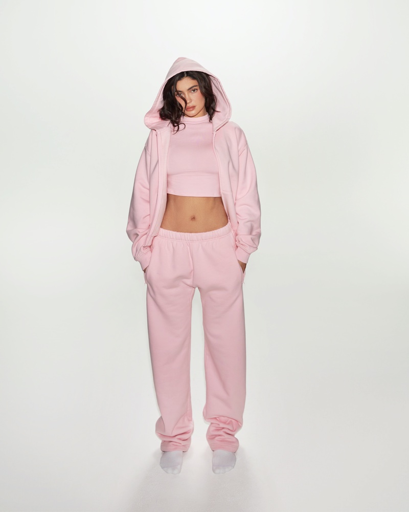 Ready to lounge in style, Kylie Jenner layers up with Khy’s soft pink hoodie over a chic crop top.
