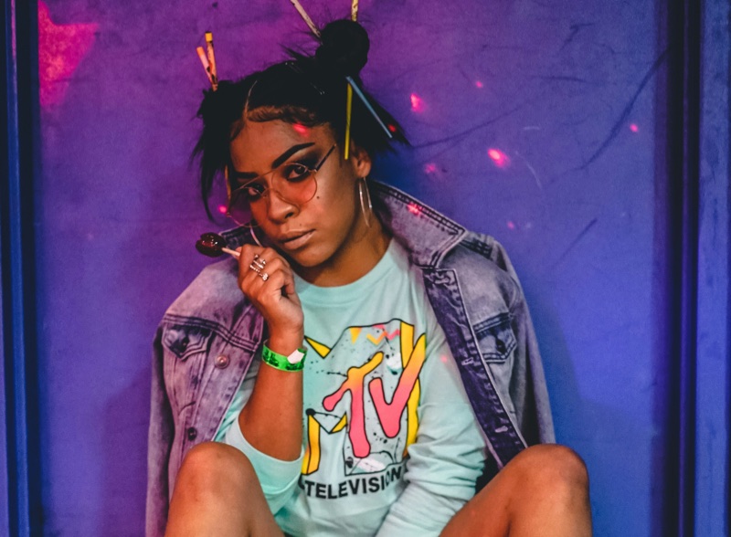 Woman wearing an MTV shirt with colorful lighting, inspired by 1980s pop culture aesthetics